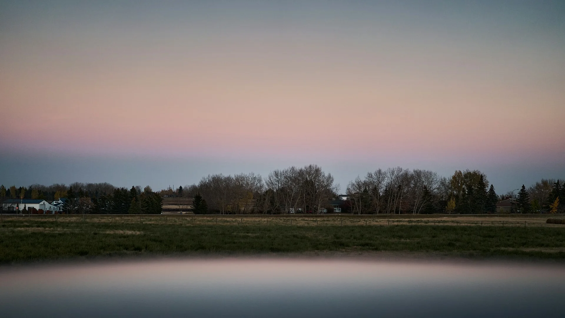 Calgary skyline at dusk with the Bow River in the foreground