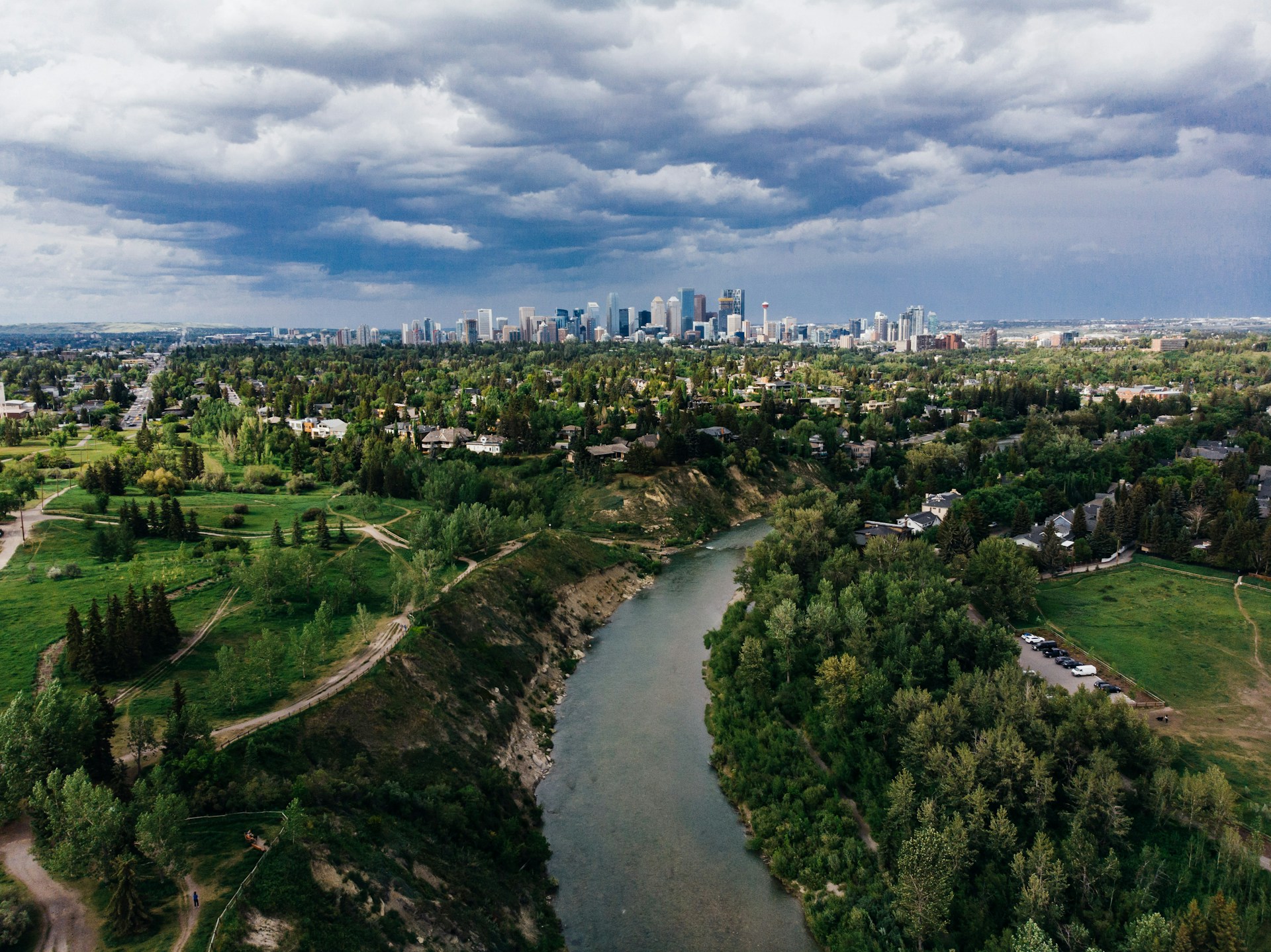 Aerial view of the Bow River and Calgary skyline with residential neighbourhoods