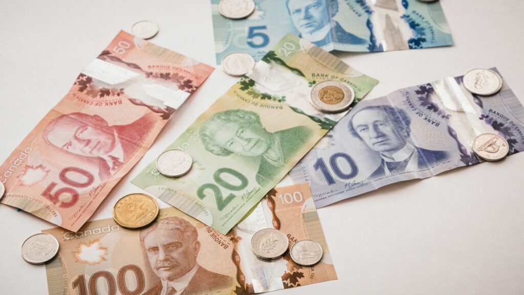 Canadian dollar bills and coins spread out representing mortgage affordability and home buying budget in Calgary