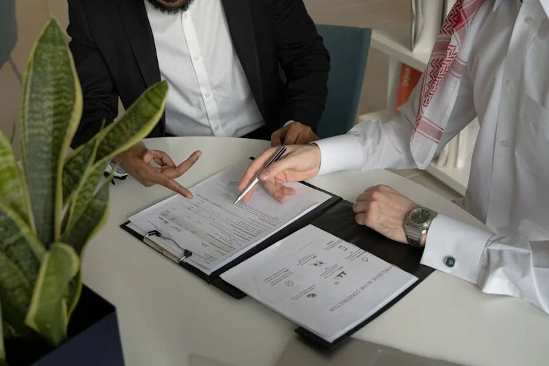 Mortgage broker reviewing documents with a homebuyer couple at a meeting table