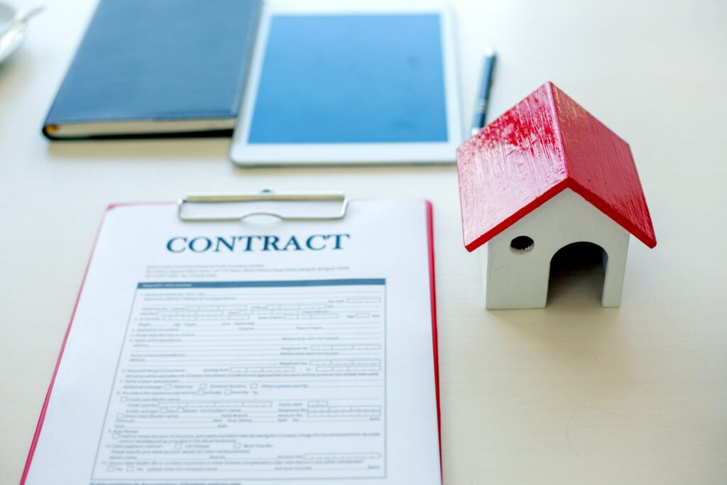 Mortgage contract document with small house model representing Calgary home buying and amortization terms