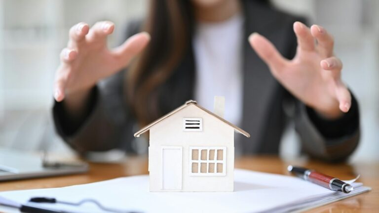 Mortgage professional reviewing refinance paperwork with model house on desk